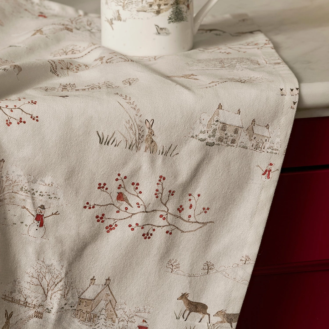 Tea towel with nature-themed design and a mug on a surface
