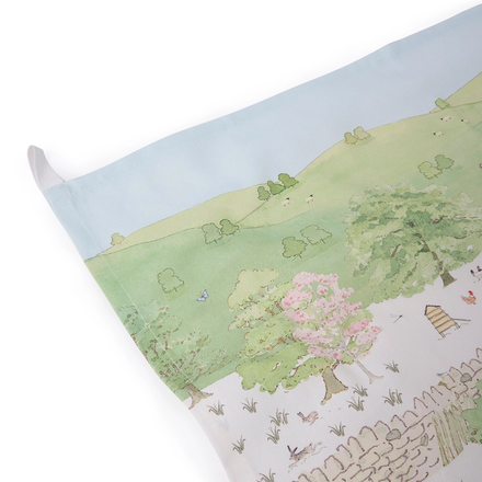 Tea towel with a scenic landscape design featuring trees, flowers, and animals on a white background.