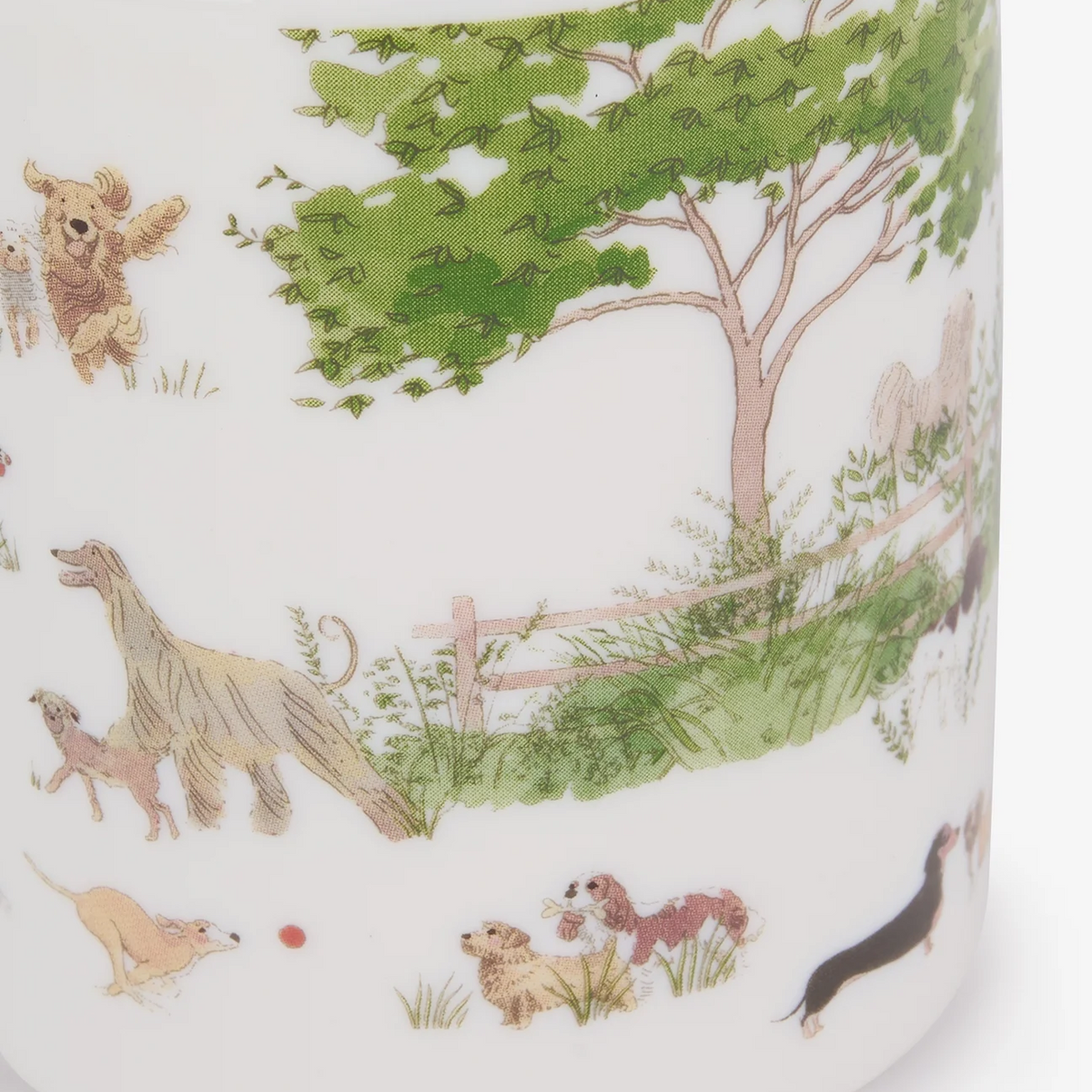 A close-up of a white china mug featuring a whimsical garden illustration with green trees and dogs in soft pastel colors.