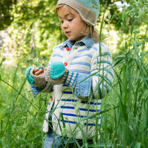 Cabbages and Kings Striped Cardigan - child wearing blue, light blue, green, and white striped cardigan with red buttons on green background