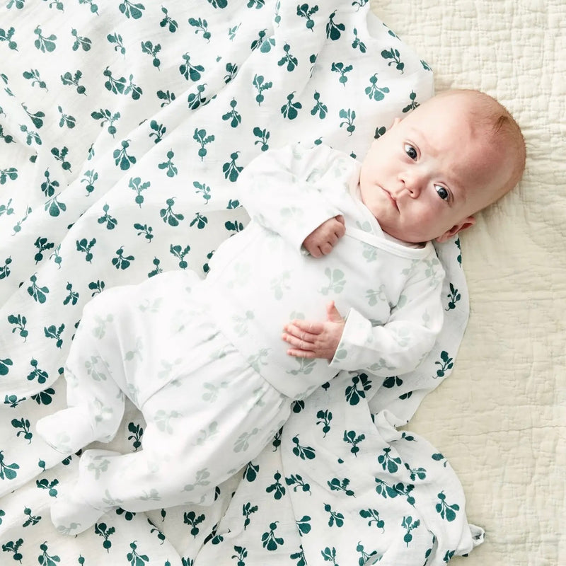 Take Me Home Outfit - baby in a white kimono style top and footie pants with pale green radish pattern on a neutral background