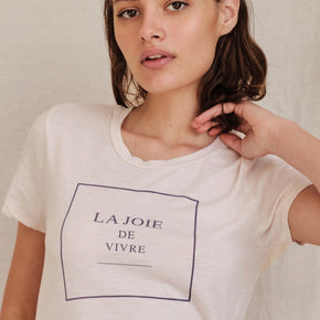 Sundry Vivre Boy Tee - model wearing white t-shirt with with black text "la joie de vivre" outlined in a black square on a neutral background