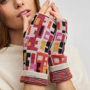 Kuna Wadja Alpaca Gloves - model wearing red, pink, yellow, black and white geometric patterned gloves on a neutral background