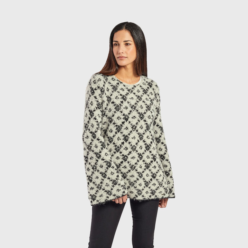 Kuna Warmi Sweater - model wearing black and white patterned sweater with bell sleeves on a neutral background