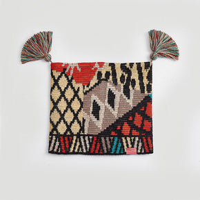 Kuna Watanabe Hat - yellow, black, red, and blue patterned hat with pom pom detail on a neutral background