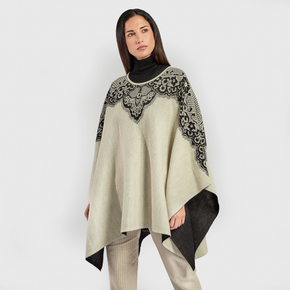 Kuna Wendy Poncho - model wearing white poncho with black lining and floral detail on a neutral background