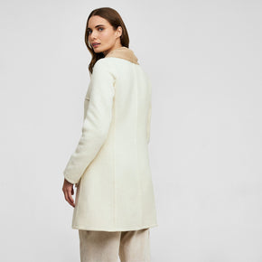 Kuna Willianne Coat - model wearing white coat with tan lining on a neutral background