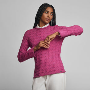 Kuna Willow Sweater - model wearing pink mock turtle neck sweater with cabling on a neutral background
