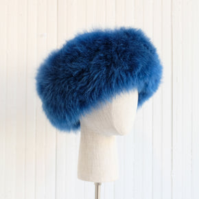 Premium Baby Alpaca Fur Hat. A blue Premium Baby Alpaca Fur Hat on a mannequin head against a white paneled background.