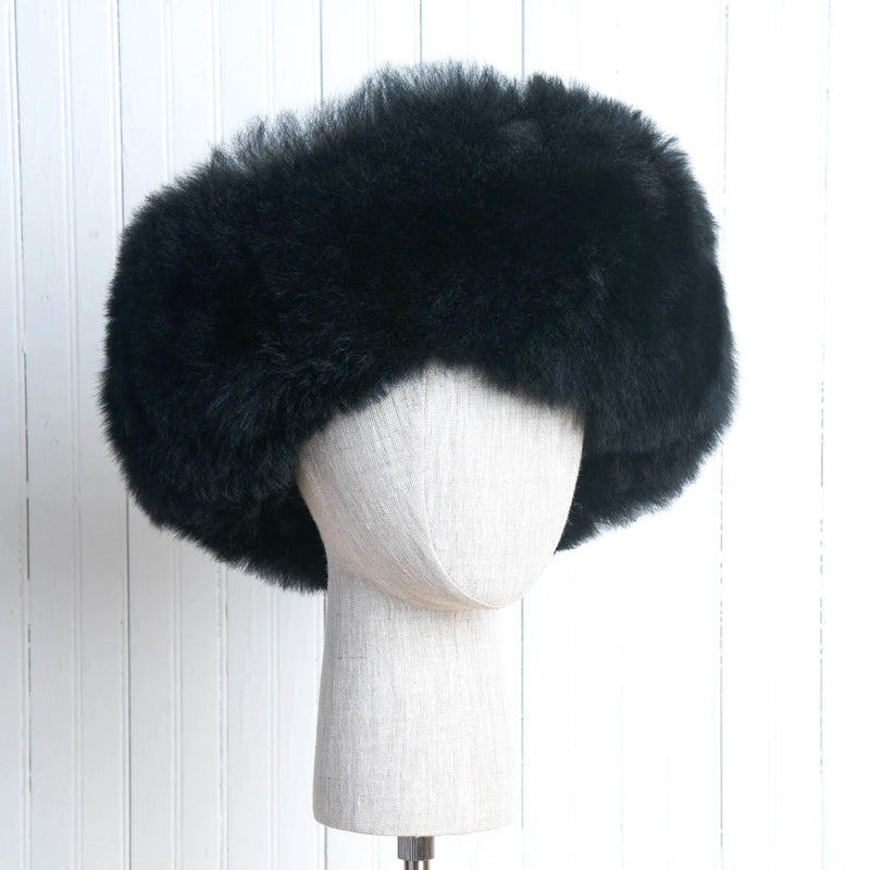 Premium Baby Alpaca Fur Hat. A black Premium Baby Alpaca Fur Hat on a mannequin head against a white paneled background.