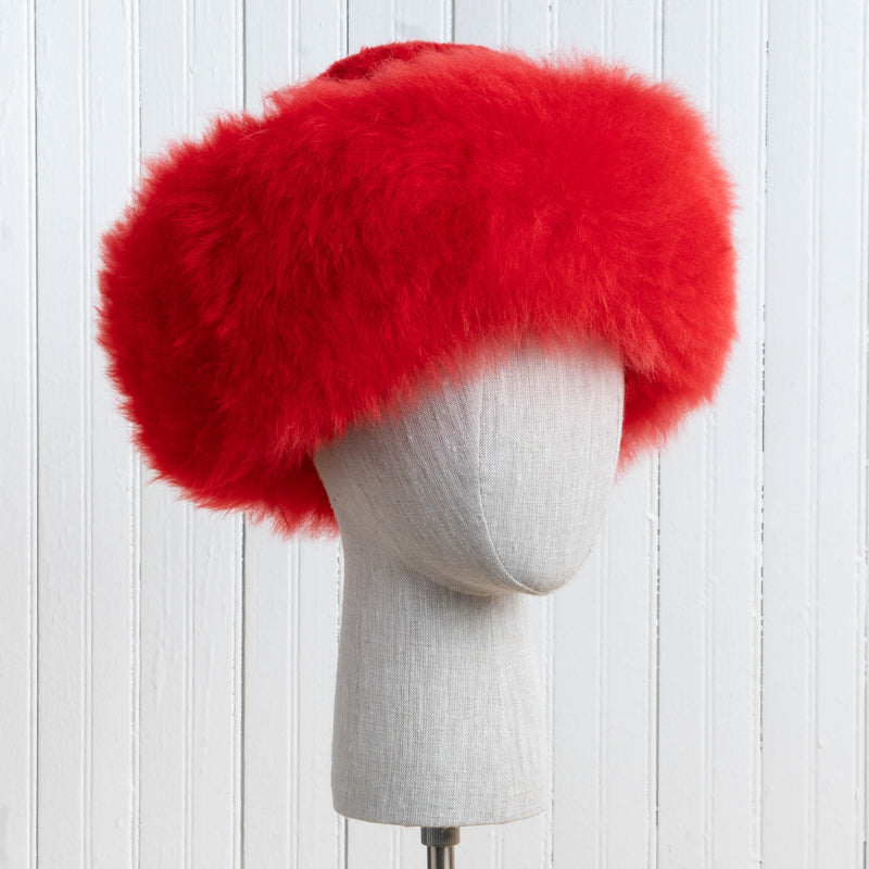 Premium Baby Alpaca Fur Hat. A red Premium Baby Alpaca Fur Hat on a mannequin head against a white paneled background.