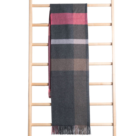 Plaid scarf draped over a wooden ladder against a white wooden panel background