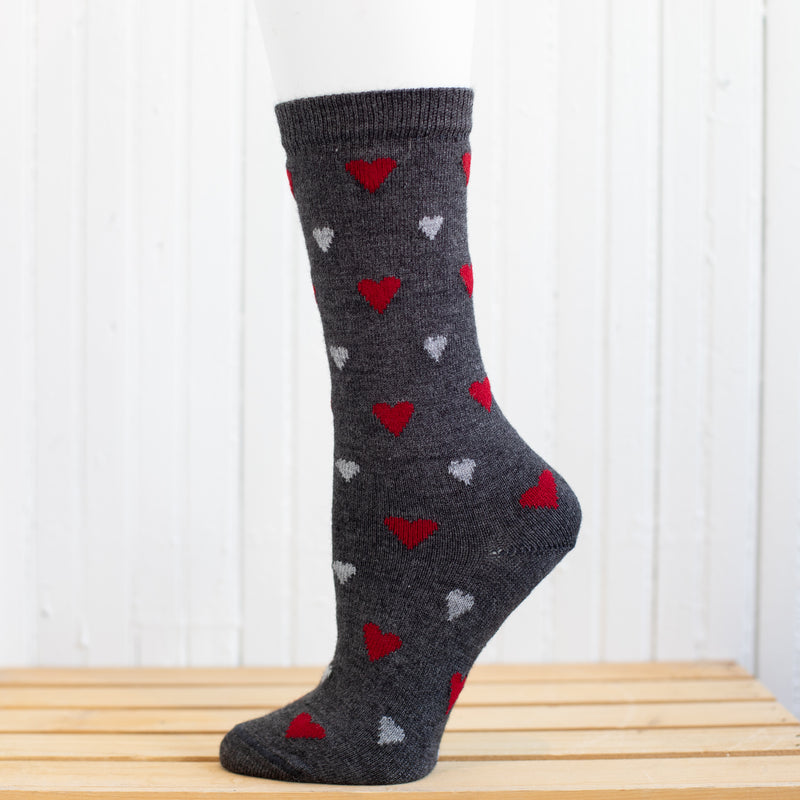A heart patterned alpaca sock in front of a white background