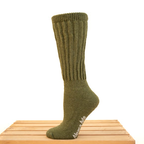 Tey-Art Therapeutic Ribbed Alpaca Socks - A foot on a wooden crate wears Olive Tey-Art Therapeutic Ribbed Alpaca Socks against a white background.