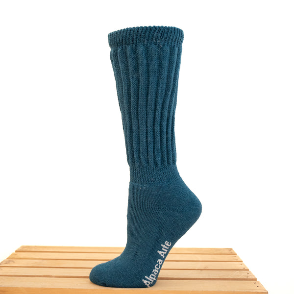 Tey-Art Therapeutic Ribbed Alpaca Socks - A foot on a wooden crate wears teal Tey-Art Therapeutic Ribbed Alpaca Socks against a white background.