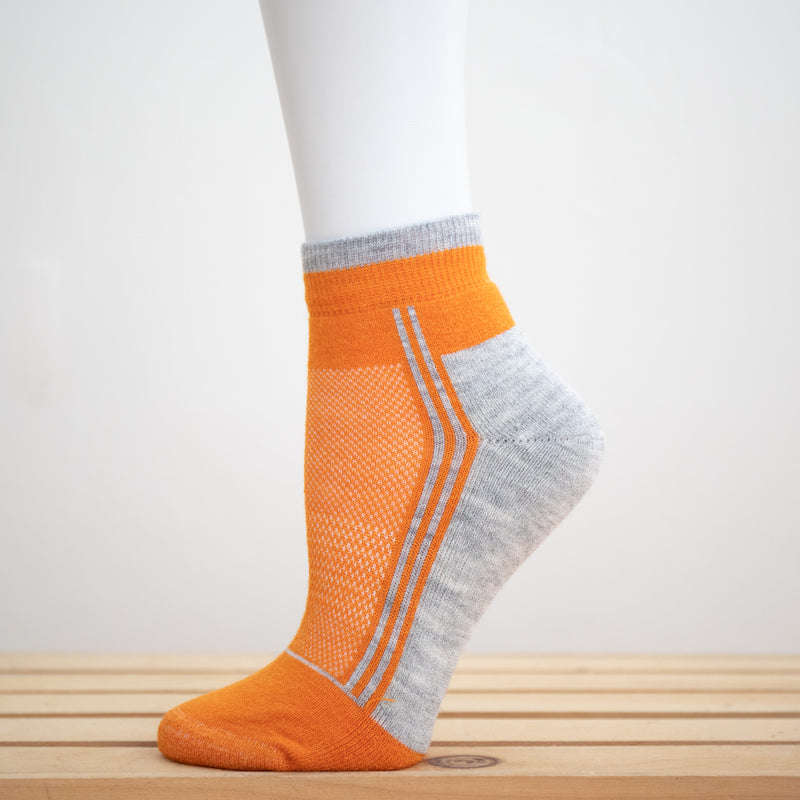 Alpaca Running  and Athletic Ankle Socks. A pair of orange alpaca ankle running socks in front of a white background. 