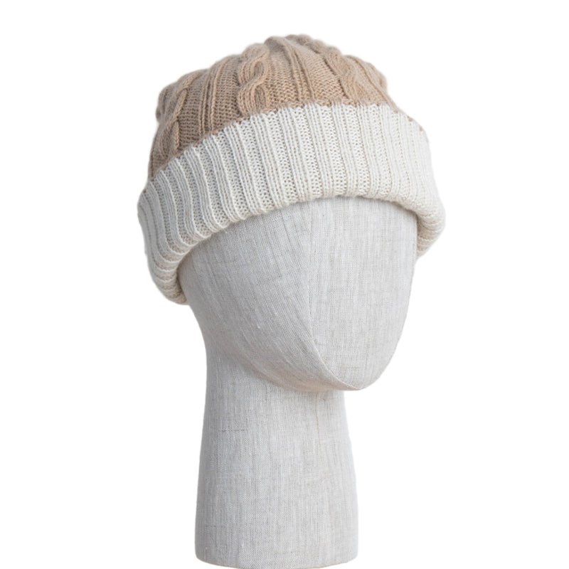 Two-tone knit beanie on a mannequin head against a light wooden panel background