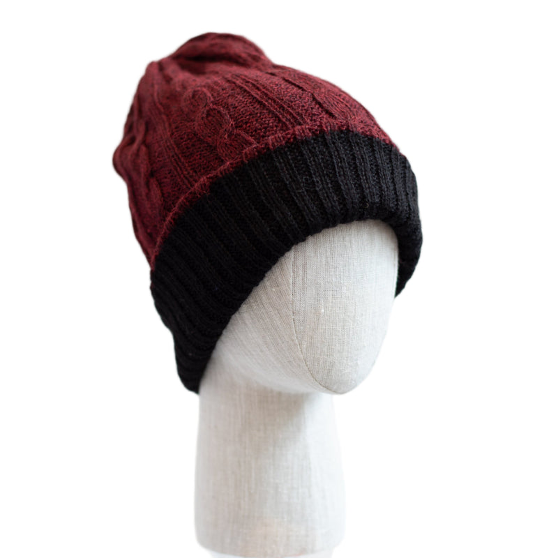 Two-tone red and black beanie on a mannequin head against a white background