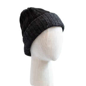 Dark gray knit beanie on a mannequin head against a white background