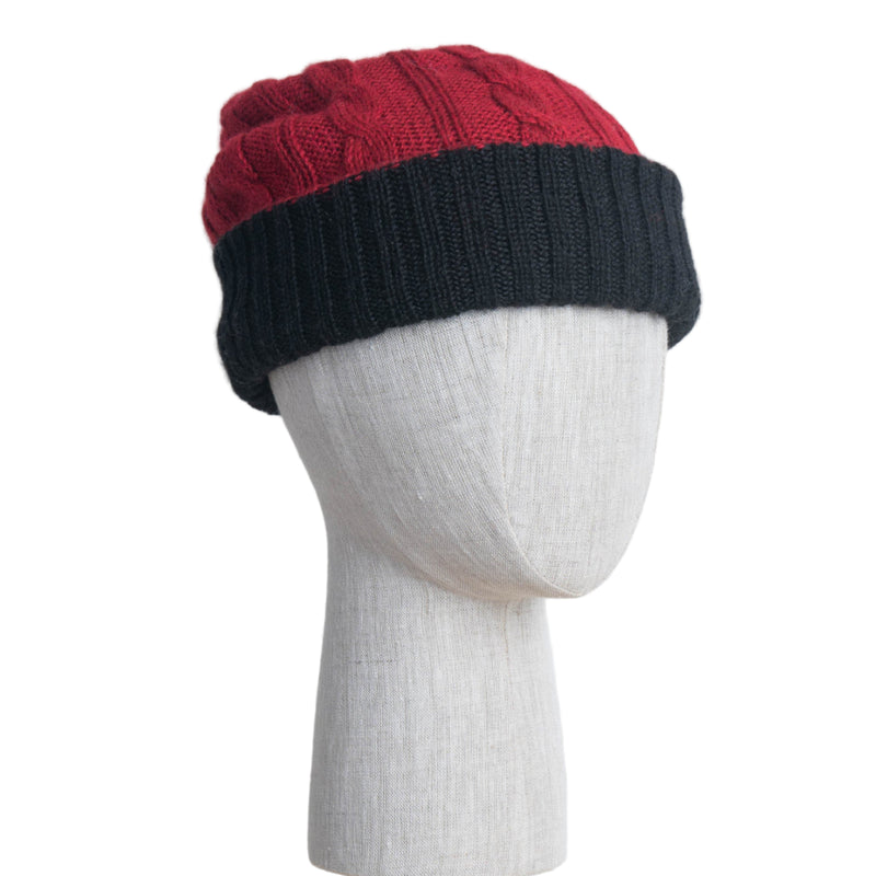 Two-tone red and black knit beanie on a mannequin head against a white background