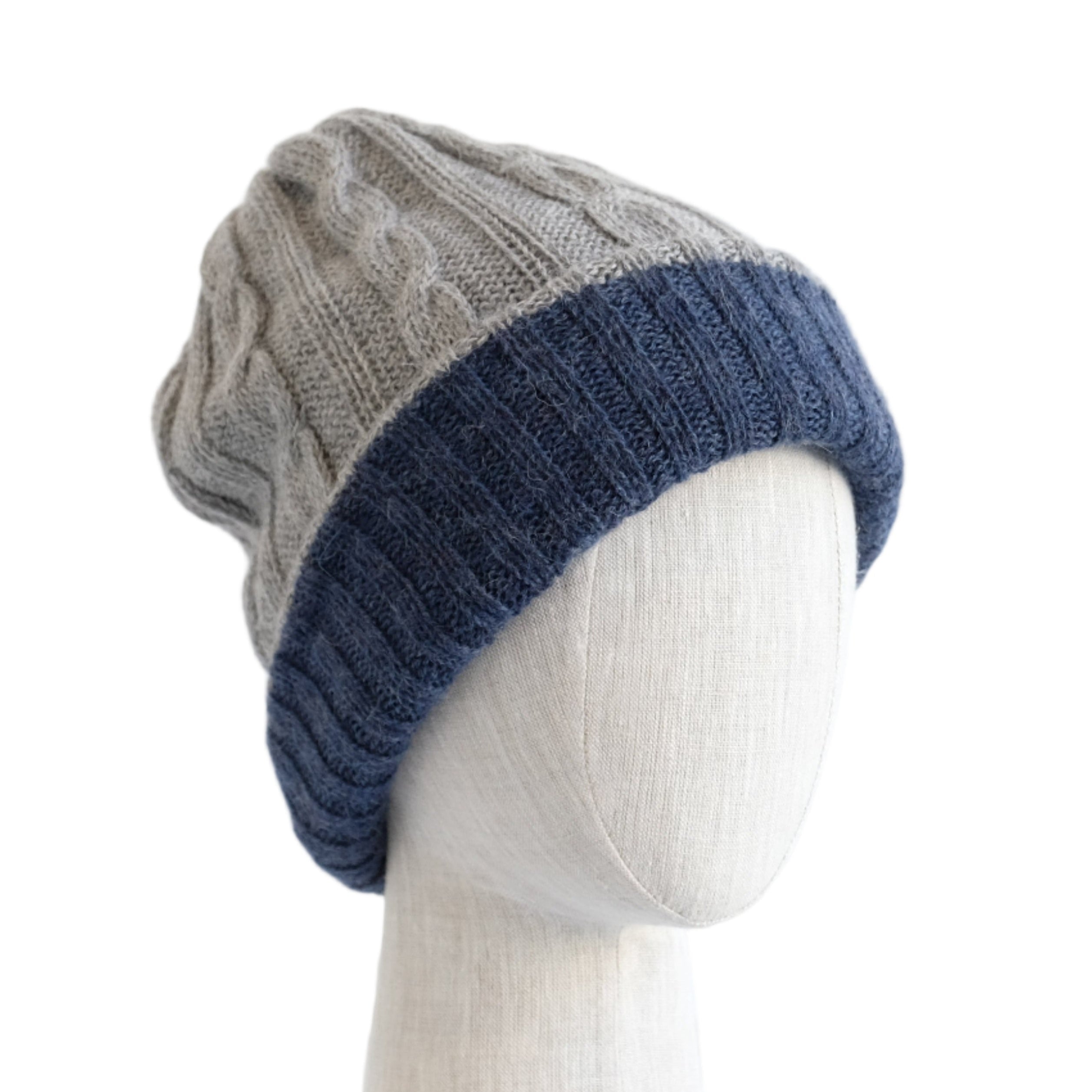 Two-toned knit beanie on a mannequin head against a white wooden panel background