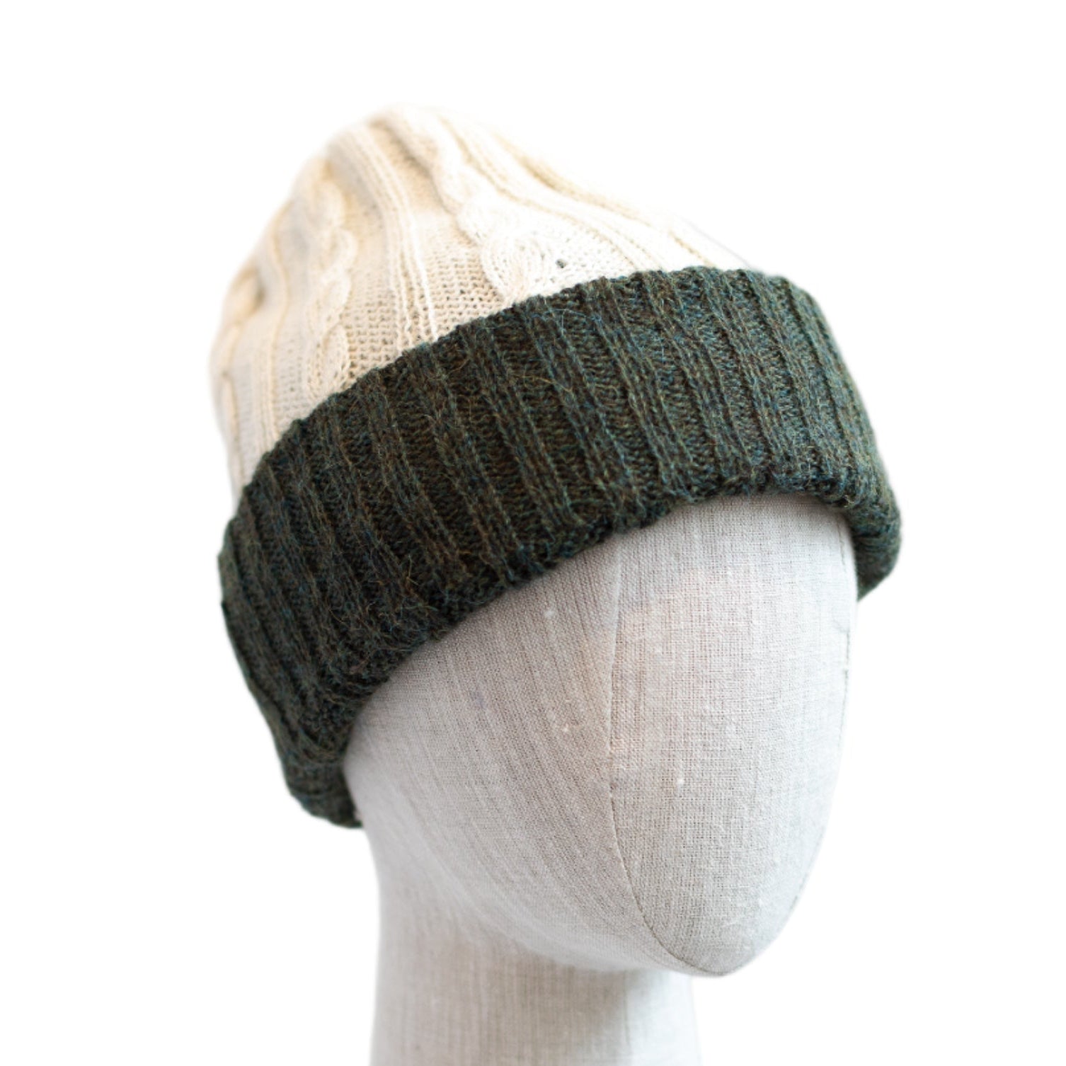 Green knit beanie on a mannequin head against a white background