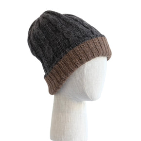 Two-tone beanie with dark gray top and brown bottom on a mannequin head against a white wooden panel background.