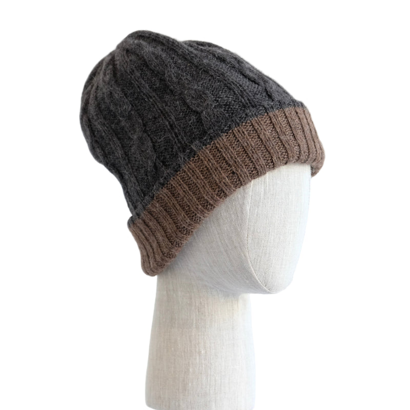 Two-tone beanie with dark gray top and brown bottom on a mannequin head against a white wooden panel background.