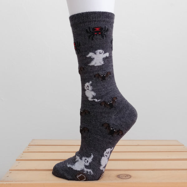 A halloween alpaca sock patterned with spiders, ghosts, bats and gravestones. 