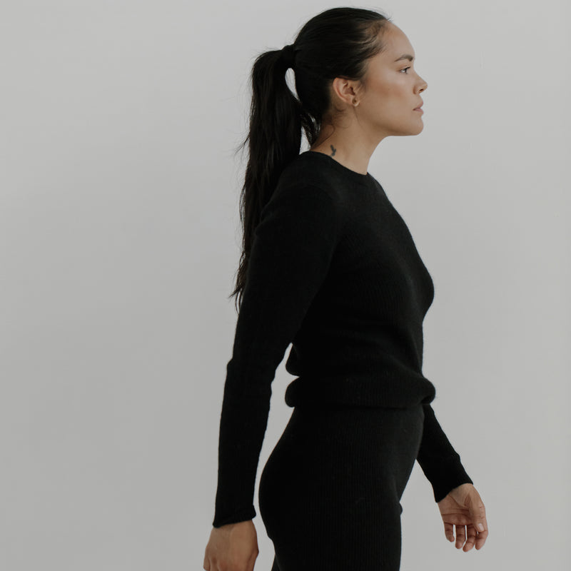 Bare Knitwear Marin Rib Top - person wearing a black long sleeved top on a neutral background