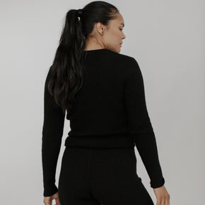 Bare Knitwear Marin Rib Top - person wearing a black long sleeved top on a neutral background
