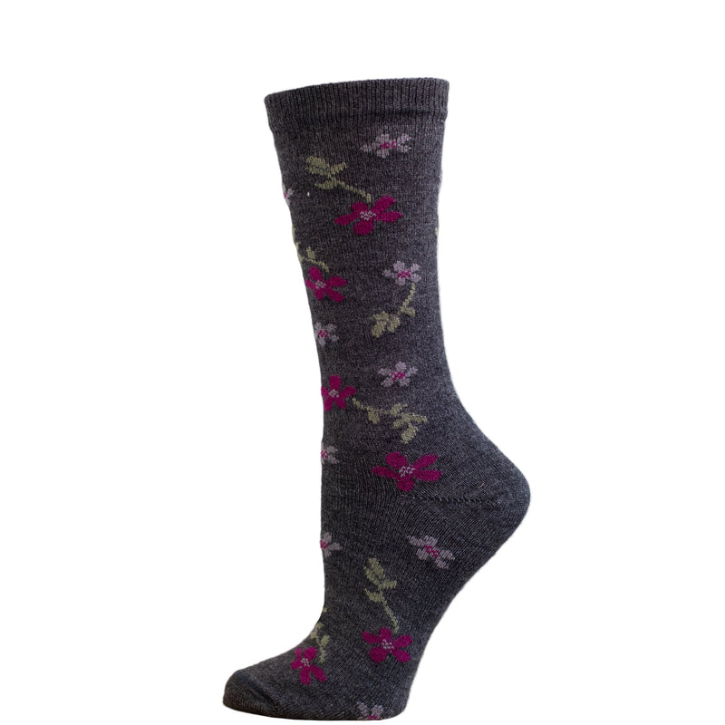 A pair of alpaca socks with a red maple flower pattern, displayed against a wooden backdrop.