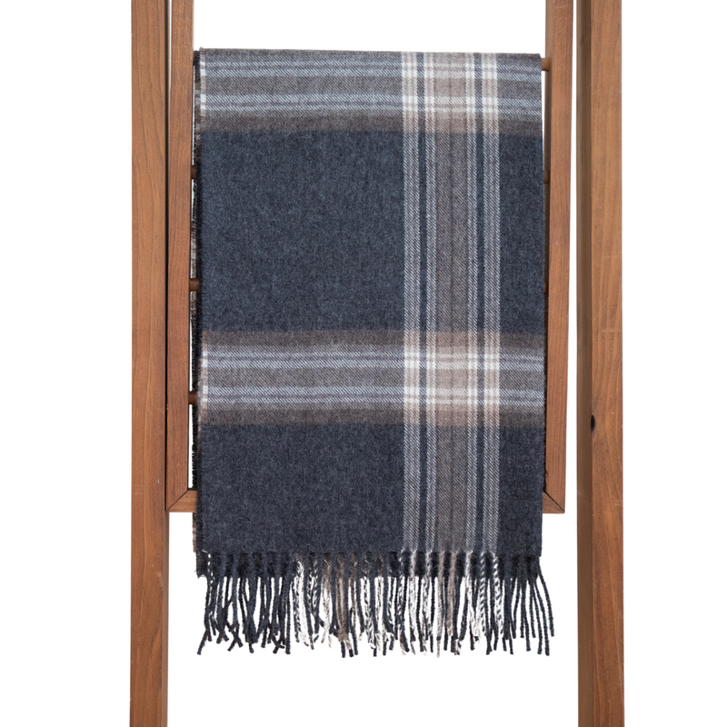 A multicolored plaid baby alpaca shawl displayed on a wooden hanger, with a variety of colors including blue, red, orange, and purple.