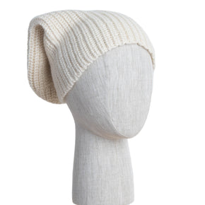 Knitted cream beanie on a mannequin head against a white wooden panel background