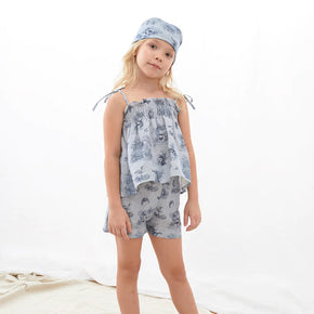 Oeuf Kids Smocked Set – 50% cotton, 50% linen blend for summer, a girl wearing a blue toile smock set with matching bandana in front of a white background