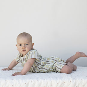 Serendipity Baby Button Suit - 100% GOTS Cotton, a  baby in. astriped onesie lying on his stomach looking at the camera against a white-gray background