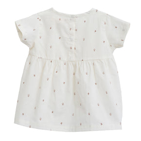 Serendipity Baby Flair Dress - 100% GOTS Certified Cotton for Summer, the back of a white baby flair dress with reddish flowers on a white background.