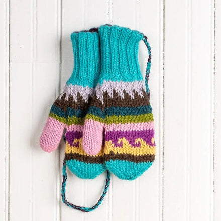 A pair of multicolor hand-knit baby alpaca mittens laid flat on a white wooden surface.