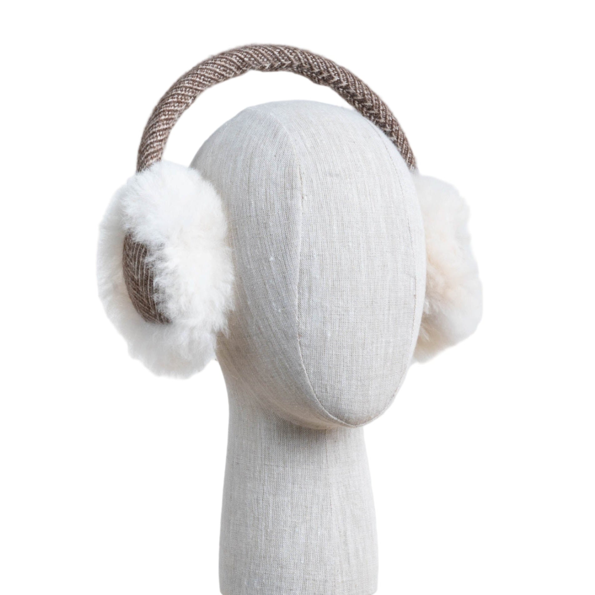 A pair of beige and white alpaca fur ear muffs displayed on a mannequin head.