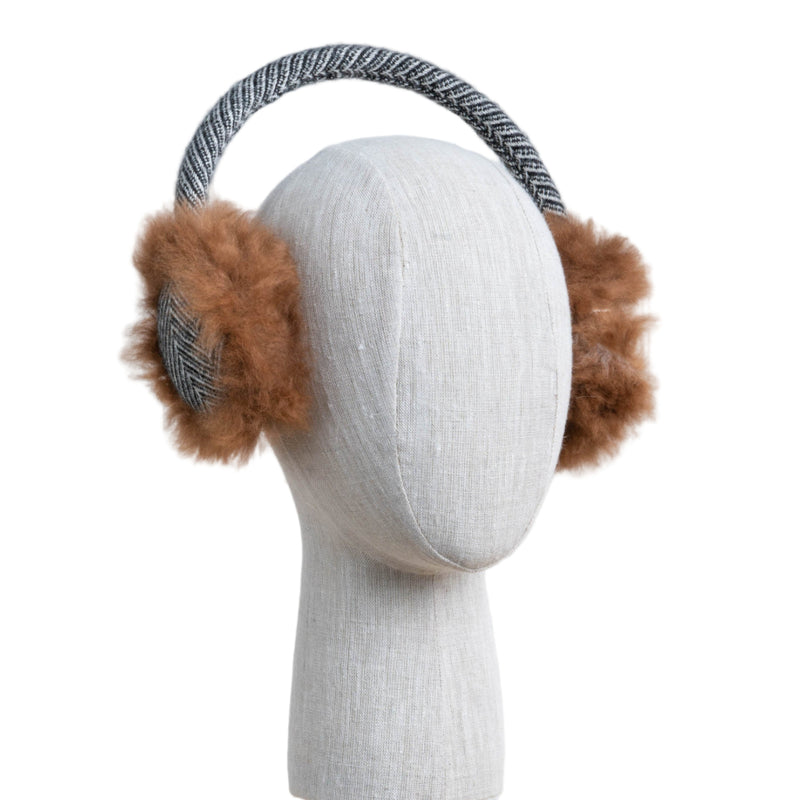 Earmuffs with brown fur on a mannequin head against a white wooden panel background