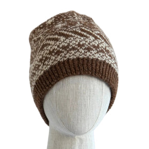 Knitted beanie on a mannequin head against a light wooden panel background