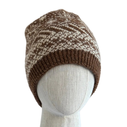 Knitted beanie on a mannequin head against a light wooden panel background