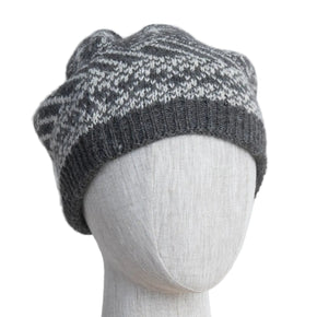 A gray and black alpaca beanie hat on a mannequin head.