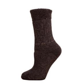 Andinista Alpaca Hiking Socks, a picture of a foot wearing a pair of brown alpaca hiking socks on a wooden crate. 