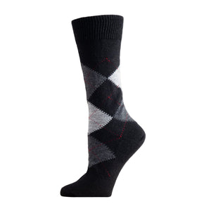 Black argyle patterned sock on a wooden surface with a white background