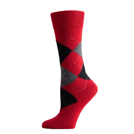 Red and black argyle sock on a wooden surface with a white background