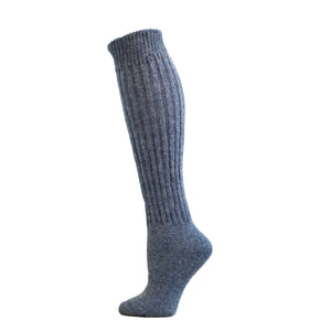 A denim blue gray knee-high sock displayed on a wooden platform with a white background.