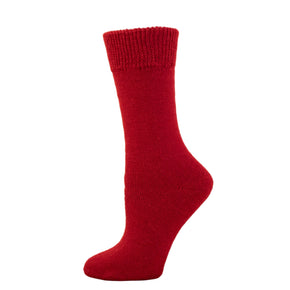 A red alpaca sport sock displayed on a wooden platform.