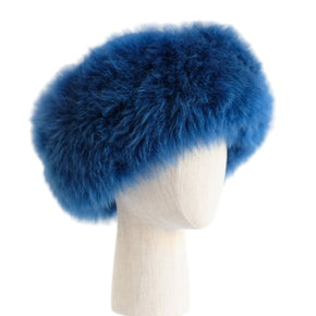 Premium Baby Alpaca Fur Hat. A blue Premium Baby Alpaca Fur Hat on a mannequin head against a white paneled background.