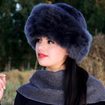 Premium Baby Alpaca Fur Hat. A woman wearing a charcoalPremium Baby Alpaca Fur Hat against a forest background.